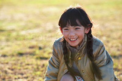 Buy stock photo Happy, calm and child by grass in nature with positive attitude for holiday, break or vacation. Smile, summer and Asian girl kid by lawn outdoor in park for development on weekend trip or getaway.