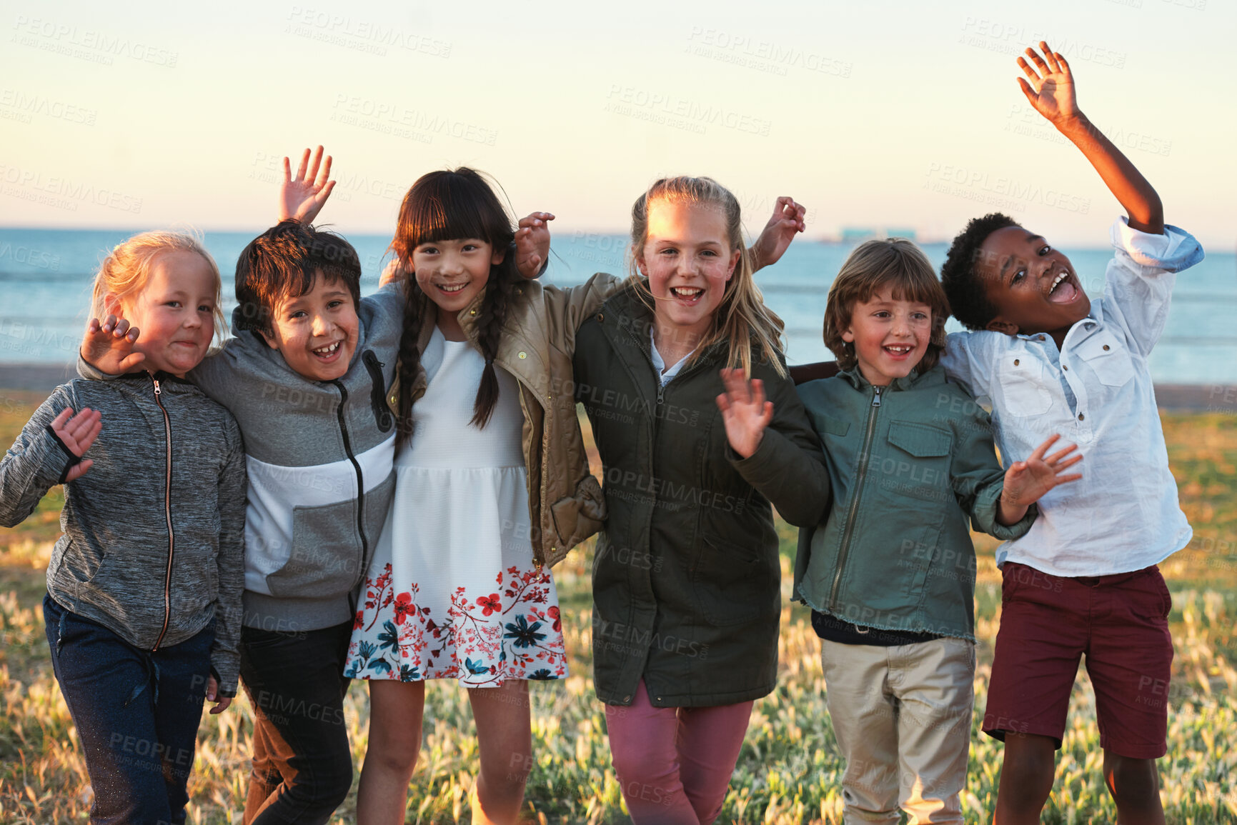 Buy stock photo Portrait, kids and excited by beach with friends, bonding together and hug outdoor for school holiday. Happy, children play and embrace by ocean with development, support and diversity on vacation.