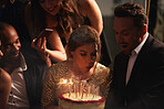 Pretty woman blowing out birthday candles at party