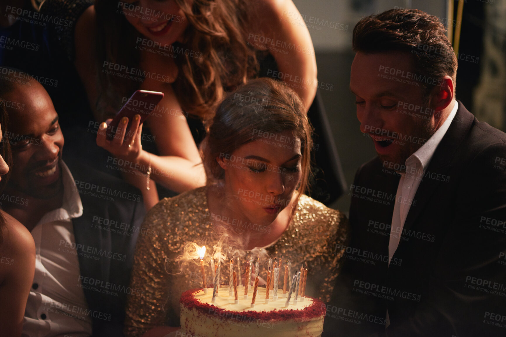Buy stock photo Night, friends and woman with birthday cake at party, celebration and social event for reunion. Blow candles, photography and happy people with dessert for special day, milestone or late get together