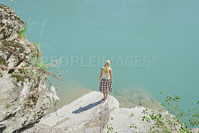 Buy stock photo Back, ocean and woman on cliff for holiday, adventure and summer getaway for sightseeing. Above, travel and female person on coastal ledge with space, scenic view and quarry water on vacation trip