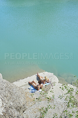 Buy stock photo Relax, sunbathing and women at ocean for travel, weekend and summer holiday in bikini. Above, friends and suntanning on coastal rock with space, tropical getaway and quarry water for vacation reunion