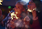 Beautiful Girl friends celebrating with sparklers having fun laughing for holiday friendship