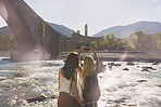 Adventure woman taking photo smart phone of rural european town travel exploration for social media