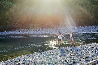 Buy stock photo Travel, walk or friends at lake with stones, fun time and bonding trip on summer break. Sunshine, space or women outdoor with adventure, vacation connection or hangout activity with balance on rock.