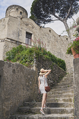 Buy stock photo Walking, holiday and woman on steps outdoor for tourism, adventure and exploration in traditional city. Stairs, back and person in historic town for summer vacation, hat and travel on journey