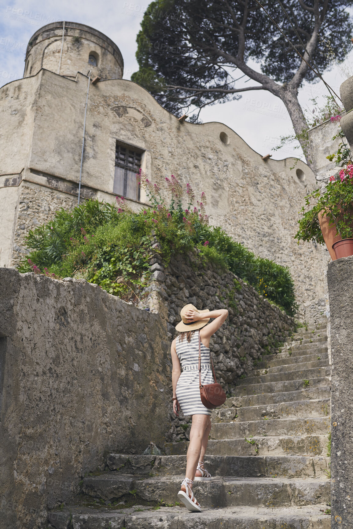 Buy stock photo Walking, holiday and woman on steps outdoor for tourism, adventure and exploration in traditional city. Stairs, back and person in historic town for summer vacation, hat and travel on journey