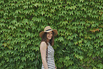 Portrait Beautiful travel woman smiling in front of wall of ivy plants on summer vacation
