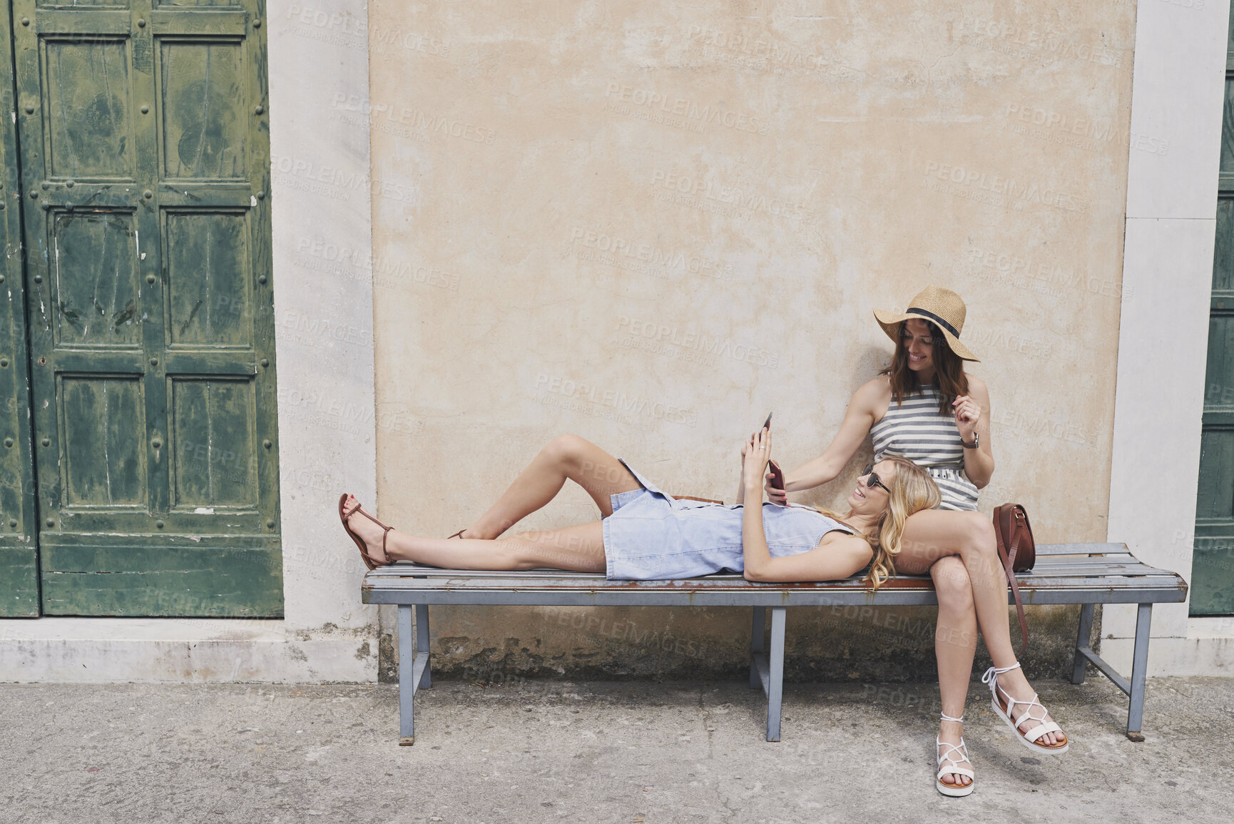 Buy stock photo Tourist girls relax in European village using smart phone to connect on adventure travel