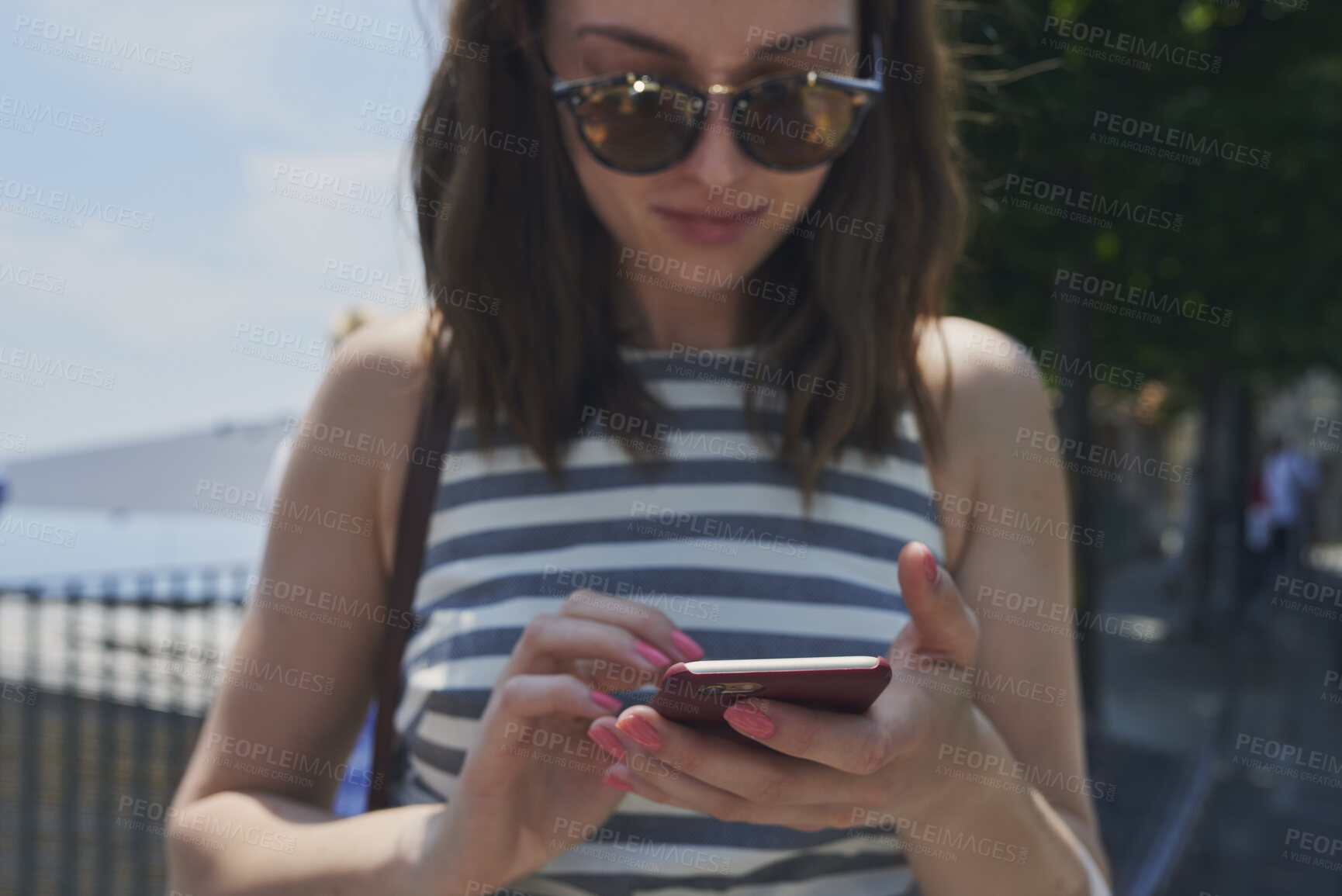 Buy stock photo Phone, sunglasses and tourism with woman outdoor at coast to search digital map for location. App, shades and typing on mobile with tourist at beach for holiday, travel or vacation directions
