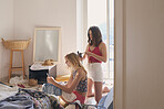 Beautiful Girl friends doing hair with straightener on summer vacation