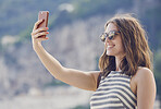 beautiful fashionable woman taking selfie smiling using smart phone technology at hotel on luxury vacation