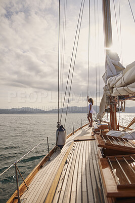 Buy stock photo Woman, sail and ocean with boat for journey, outdoor adventure or travel vacation on sea. Tourist, female person or sailor with sunshine on yacht pier for tourism, cruise or trip on coast in nature