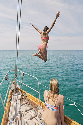 Buy stock photo Jump, travel and freedom with friends on yacht for summer vacation, diving and sea adventure. Swimming, sailing and tropical cruise with women on boat for ocean expedition, energy and journey