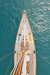 Beautiful girl friends tanning on sailboat in ocean from above overhead on luxury lifestyle adventure travel vacation 