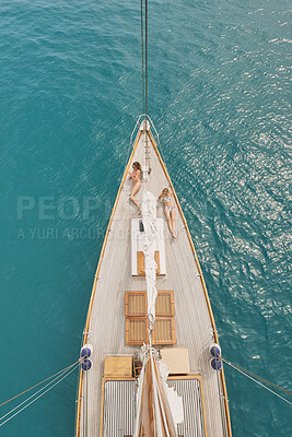 Buy stock photo Women, relax and summer holiday in ocean with boat, travel or chill outdoor on deck for luxury getaway. Above, friends rest and journey at sea with yacht, adventure and bonding together for vacation.