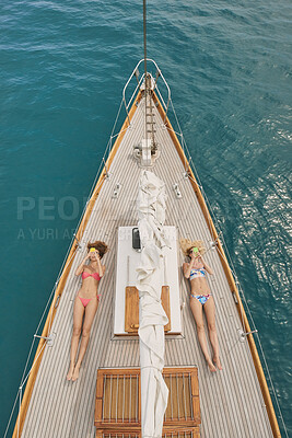 Buy stock photo Phone, travel and relax with friends on yacht for summer vacation, suntanning and seaside adventure. Social media, sailing and tropical cruise with above of women on boat for ocean and holiday post