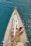 Beautiful girl friends on sailboat using smart phone technology for social media in ocean from above overhead on luxury lifestyle adventure travel vacation 