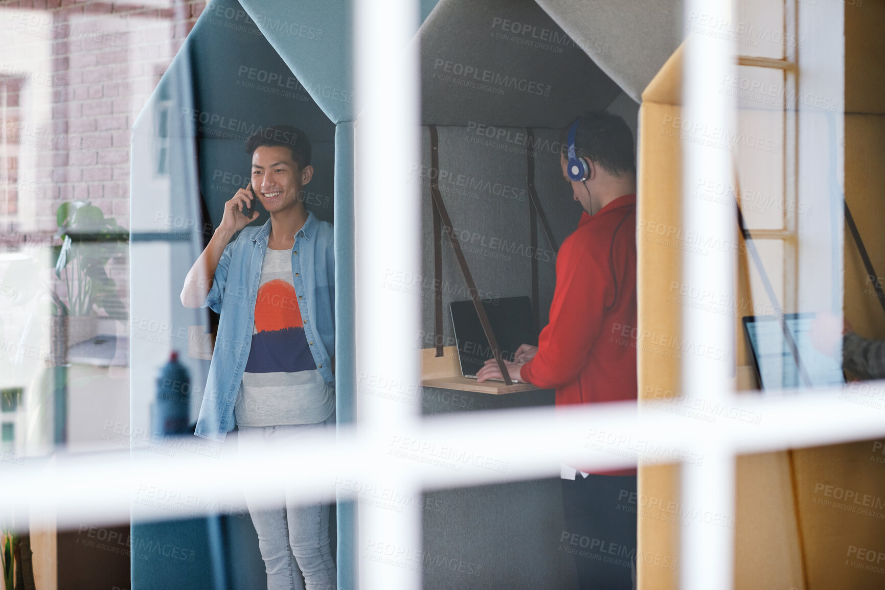 Buy stock photo Phone call, technology and window with designer people in creative workplace for communication. Conversation, laptop and smile of business man in cubicle at coworking office for design feedback
