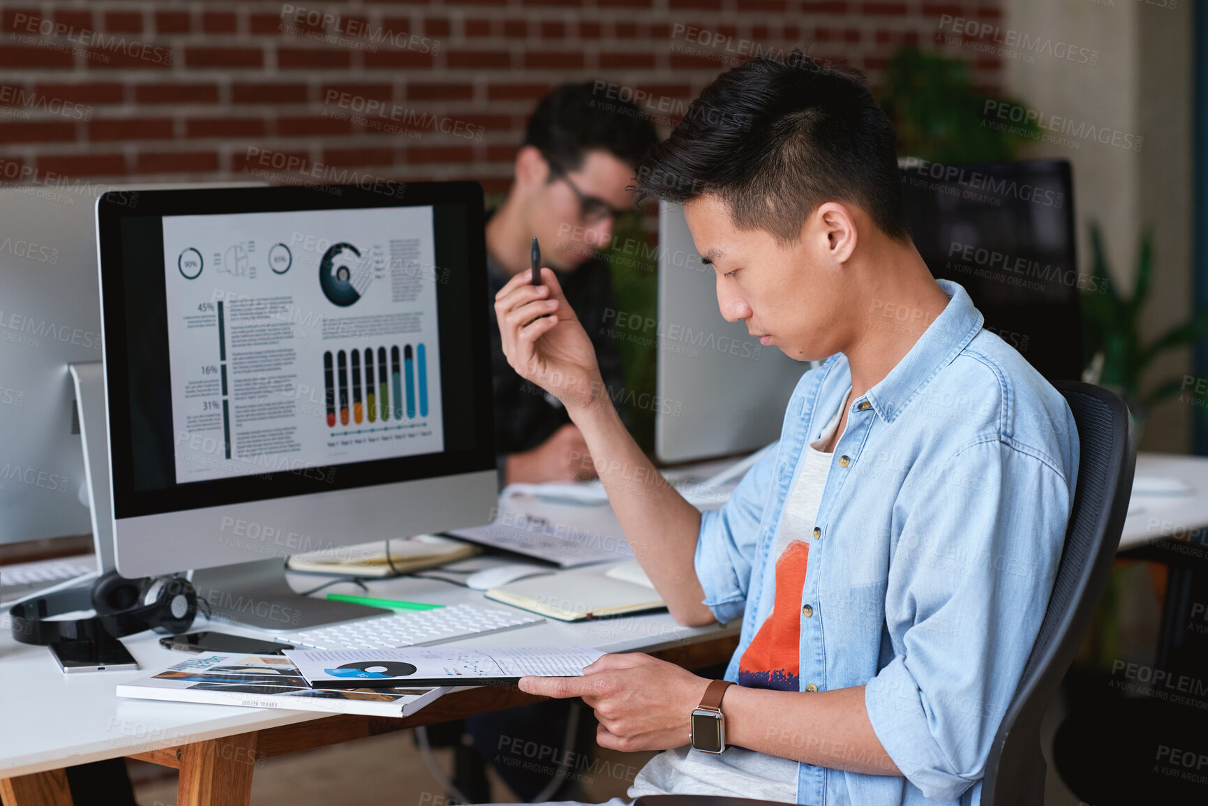 Buy stock photo Computer screen, documents and reading with designer man at desk for review of statistics. Data, digital and paperwork with design employee in workplace for analysis of charts, graphs or metrics