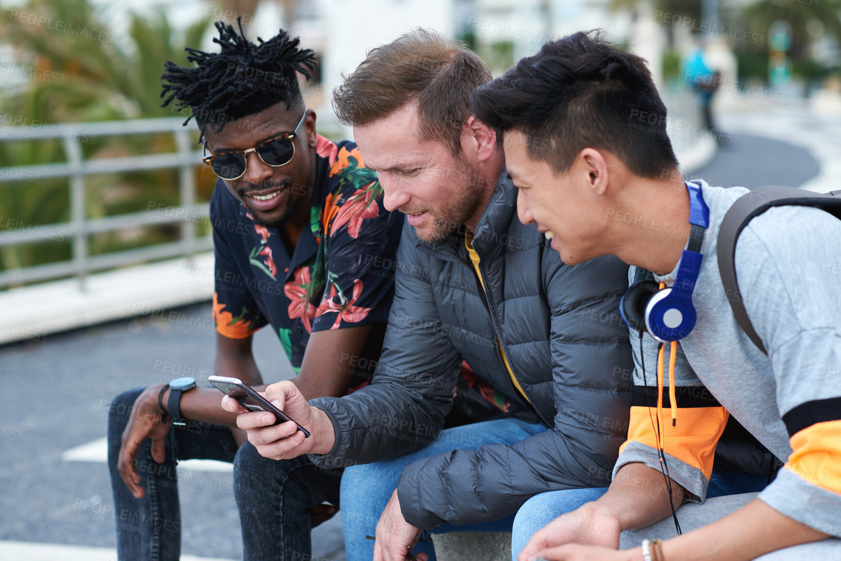 Buy stock photo Phone, friends and men outdoor for social connection, funny meme and show music playlist on internet. Group, mobile and happy people hangout with audio app, laughing and share joke online in city