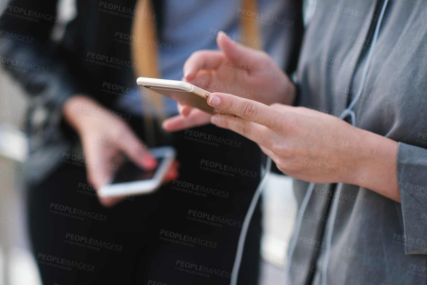 Buy stock photo Phone, friends and hands outdoor for social media, music and browsing playlist on internet. Connection, mobile and women hangout together with audio app, earphones and streaming podcast online