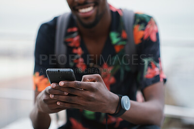 Buy stock photo Hands, typing and happy man with phone on beach promenade for online chatting or texting in nature. Male person, traveler or tourist with smile on smartphone for mobile network, app or connection