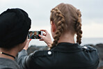 Women friends taking selfie photo on beach using smartphone hanging out by seaside sharing fun on social media with mobile phone