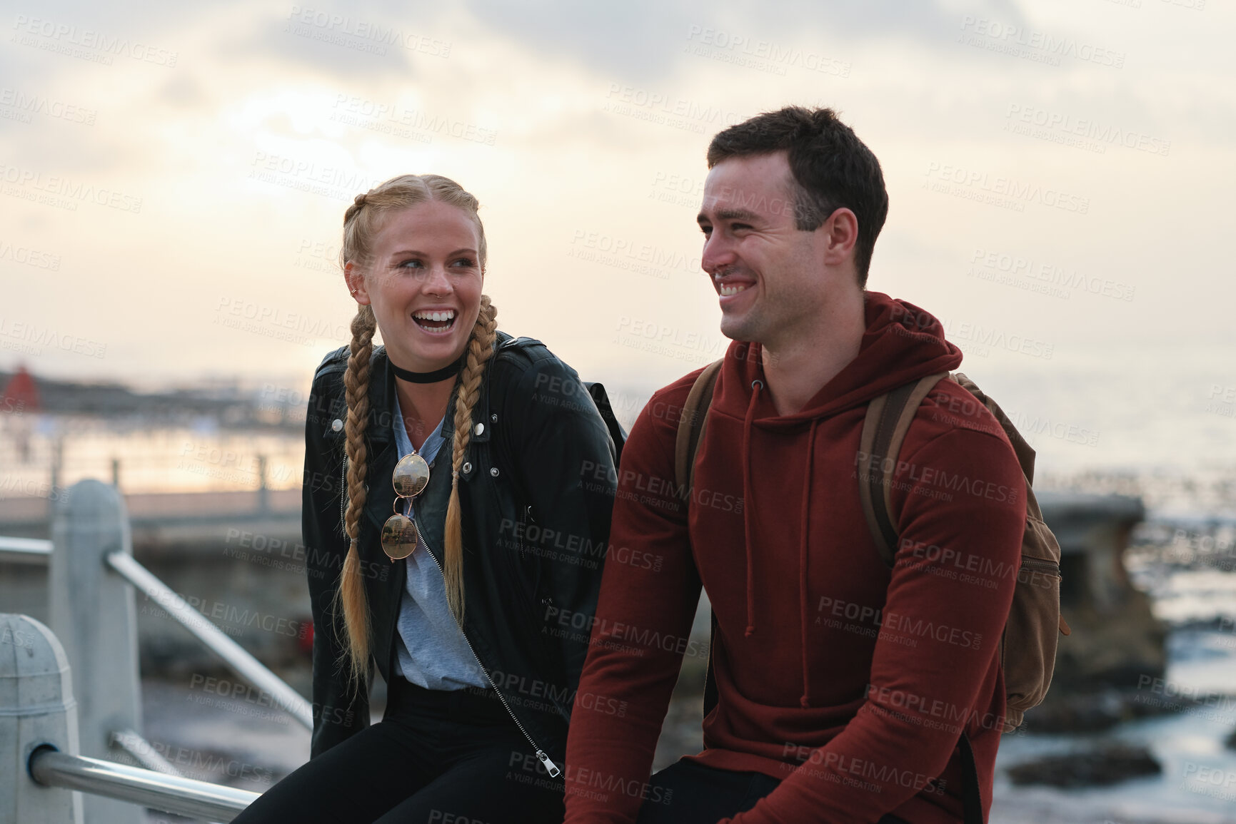 Buy stock photo Outdoor, laughing and couple with sunset for holiday, weekend break and getaway trip for connection. Evening bonding, joke and people with travel for abroad adventure, relax or vacation for happiness