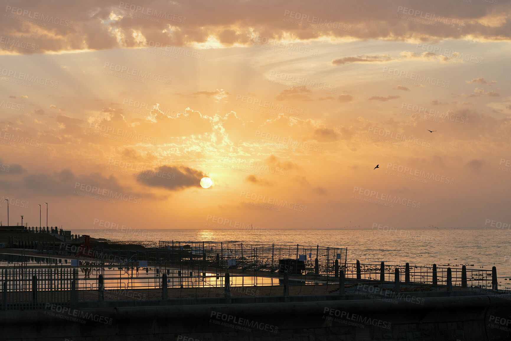 Buy stock photo Clouds, sky and sunset with pier at ocean for natural background or scenic wallpaper. Evening, horizon and space with seaside boardwalk or jetty outdoor in nature for dusk and twilight scenery