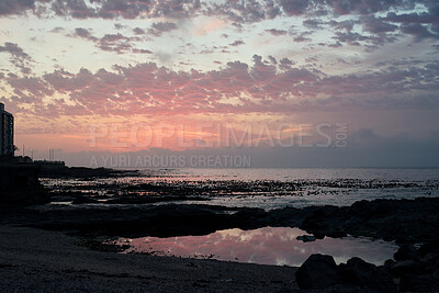 Buy stock photo Clouds, sky and sunset with view of ocean from seaside for background or scenic wallpaper. Rocks, seascape and space with water in colorful environment for calm dusk, nightfall or twilight scenery