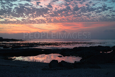 Buy stock photo Cloudy, sky and sunset with view of ocean from seaside for background or scenic wallpaper. Rocky, seascape and space with water in colorful environment for calm dusk, nightfall or twilight scenery