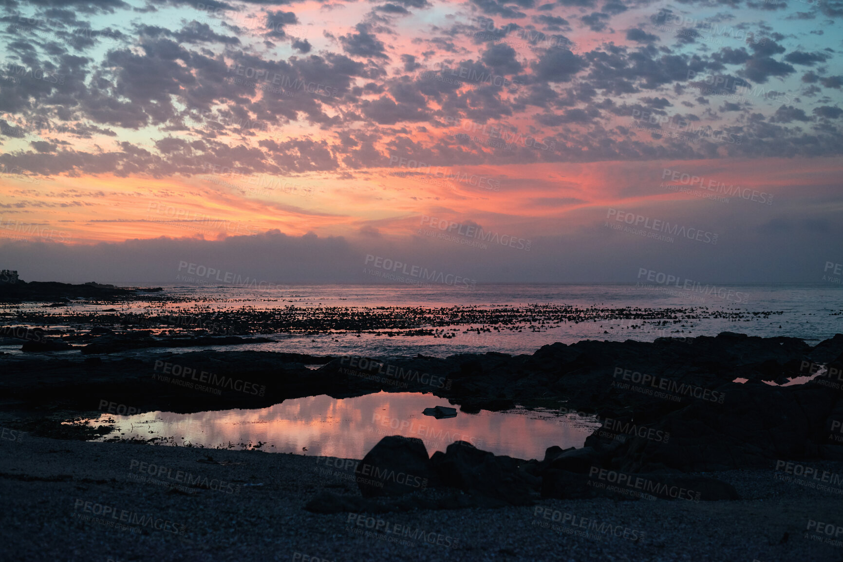 Buy stock photo Cloudy, sky and sunset with view of ocean from seaside for background or scenic wallpaper. Rocky, seascape and space with water in colorful environment for calm dusk, nightfall or twilight scenery