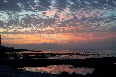 Buy stock photo Rocky, sky and sunset with view of ocean from seaside for background or scenic wallpaper. Cloudy, seascape and space with water in colorful environment for calm dusk, nightfall or twilight scenery
