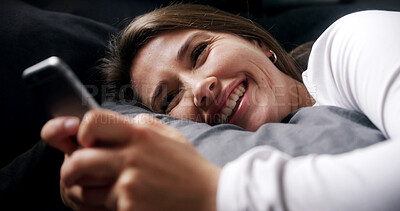 Buy stock photo Laugh, relax and woman in bed with phone, text or reading funny meme on social media in home. Smile, chill or person in bedroom on mobile app for typing message, morning notification or communication
