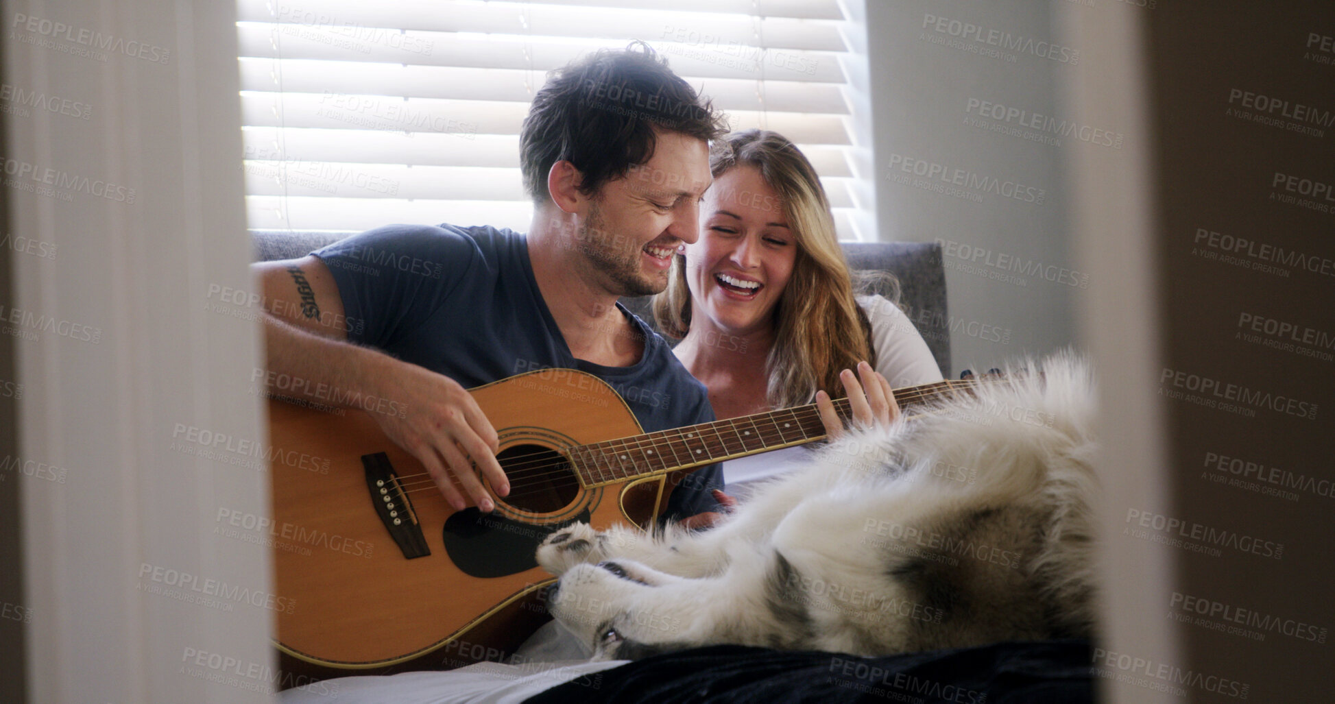 Buy stock photo Guitar, husky and laughing with couple in home together for bonding, connection or security. Dog, music and pet owner people playing instrument in apartment for break, funny or humor on weekend