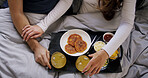 Hands, healthy food and couple in bed with breakfast, celebration and nutrition for wellness. Above, people and appreciation at house with brunch, orange juice and bonding together for anniversary