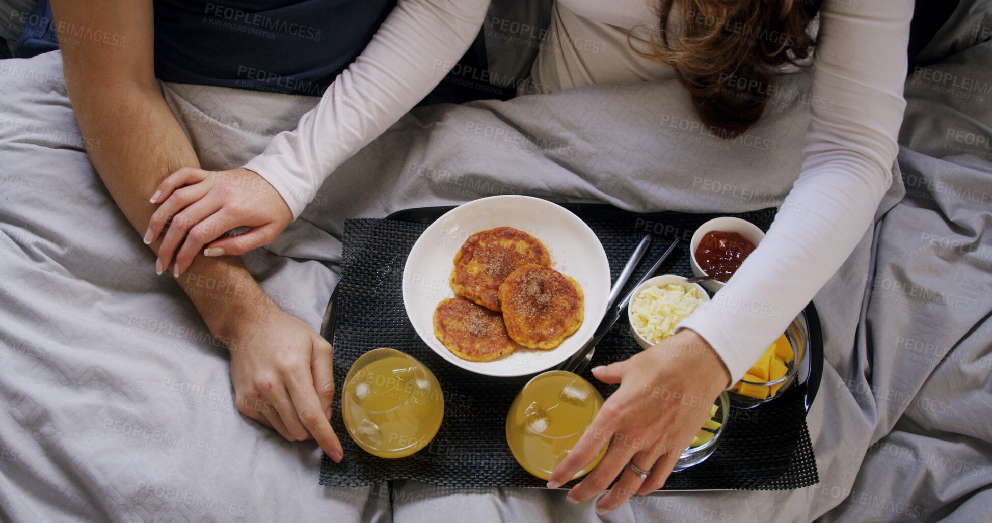 Buy stock photo Hands, healthy food and couple in bed with breakfast, celebration and nutrition for wellness. Above, people and appreciation at house with brunch, orange juice and bonding together for anniversary