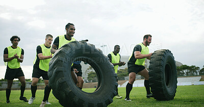 Buy stock photo Men, training and sport with tire on grass field for outdoor exercise, workout or drill together. Active, male people or athletic players with wheel for strength, endurance or rugby practice on pitch