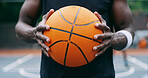 Basketball, sport and hands in court with ball for competition, game or match in urban park. Grip, male person or athlete playing with object for training, exercise or tournament on practice pitch