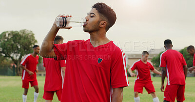 Buy stock photo Break, drinking water and soccer with man outdoor on grass pitch for fitness or hydration. Bottle, health and sports with thirsty football player on field for competition, game or match practice