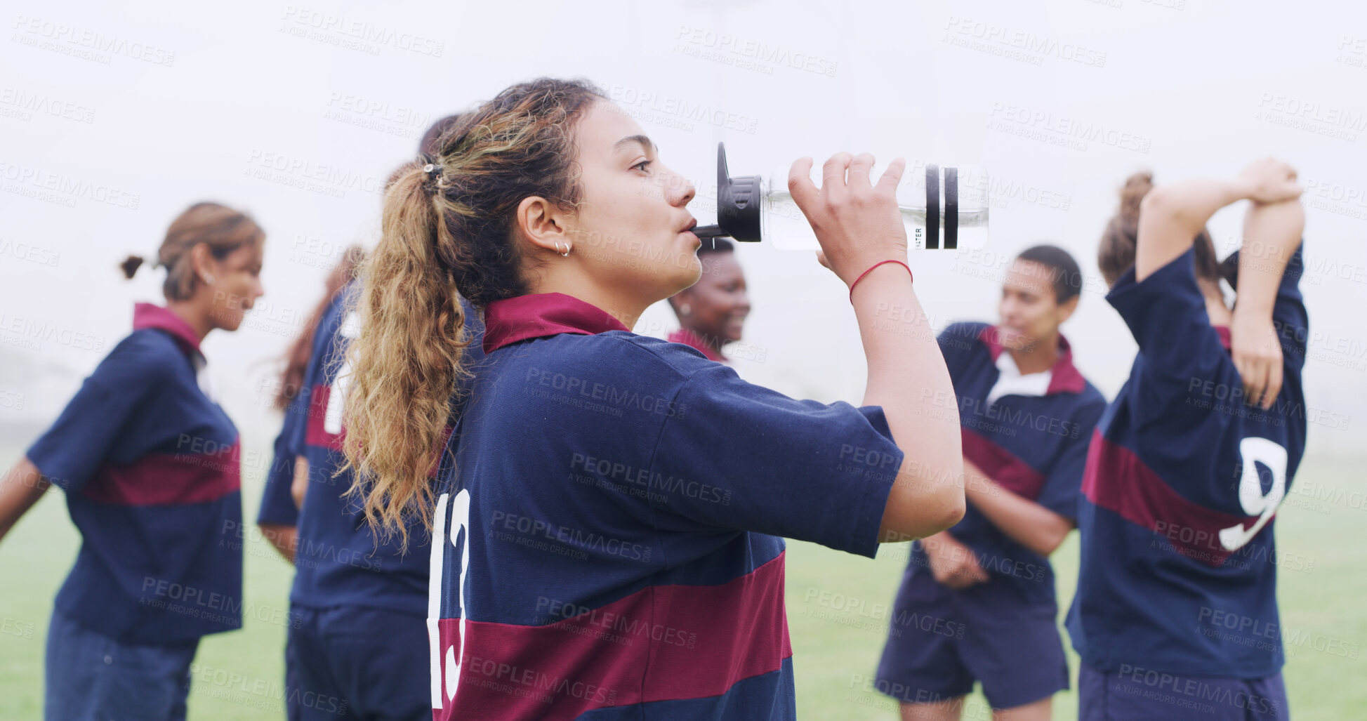 Buy stock photo Drinking, water and rugby with woman on field for training break, hydration and competition practice. Electrolyte, match rest and exercise fatigue with person outdoor for sports, wellness and energy