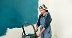 Woman, wall and painting for renovation with smile, roller and color for property development. Person, interior design, tools and equipment with application, space and ladder for home improvement