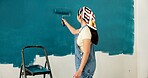 Woman, roller and painting wall with stroke, remodeling and creativity for property development. Person, interior design and renovation with space, maintenance gear and brush for home improvement