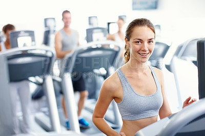 Buy stock photo Portrait of an attractive young woman jogging on a treadmill