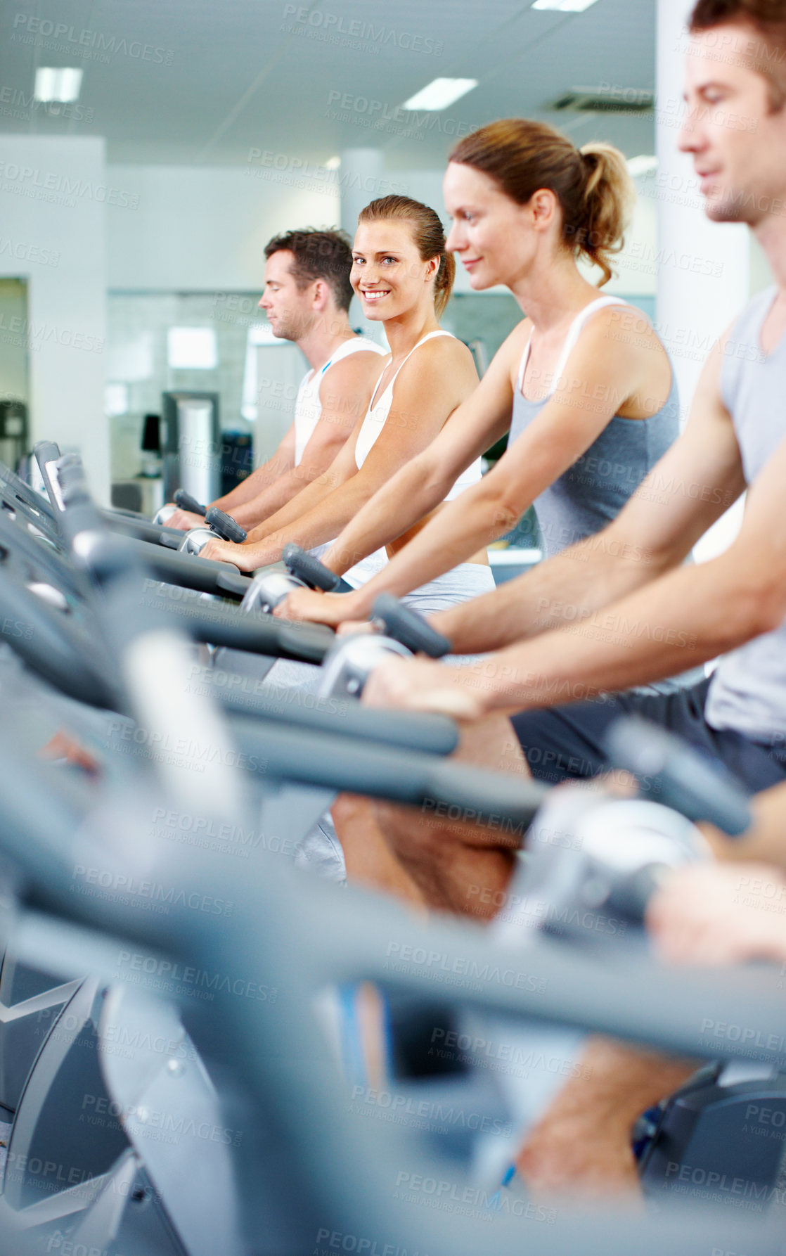 Buy stock photo Fitness, happy woman and indoor cycling at gym with spin class, wellness benefits or endurance workout. Exercise club, stationery bike and people with cardio machine, training and portrait with group