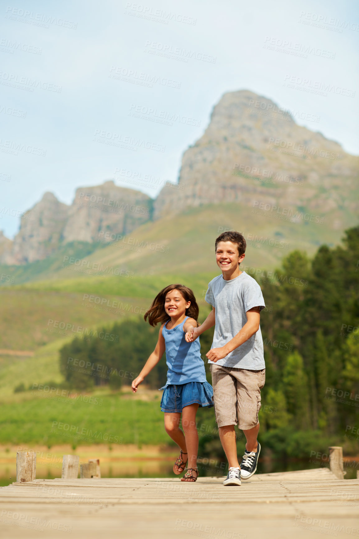 Buy stock photo Care, children and holding hands at lake, running and play together on jetty for vacation with portrait. Happy kids, brother or sister on dock for summer trip, tourism and travel with support outdoor