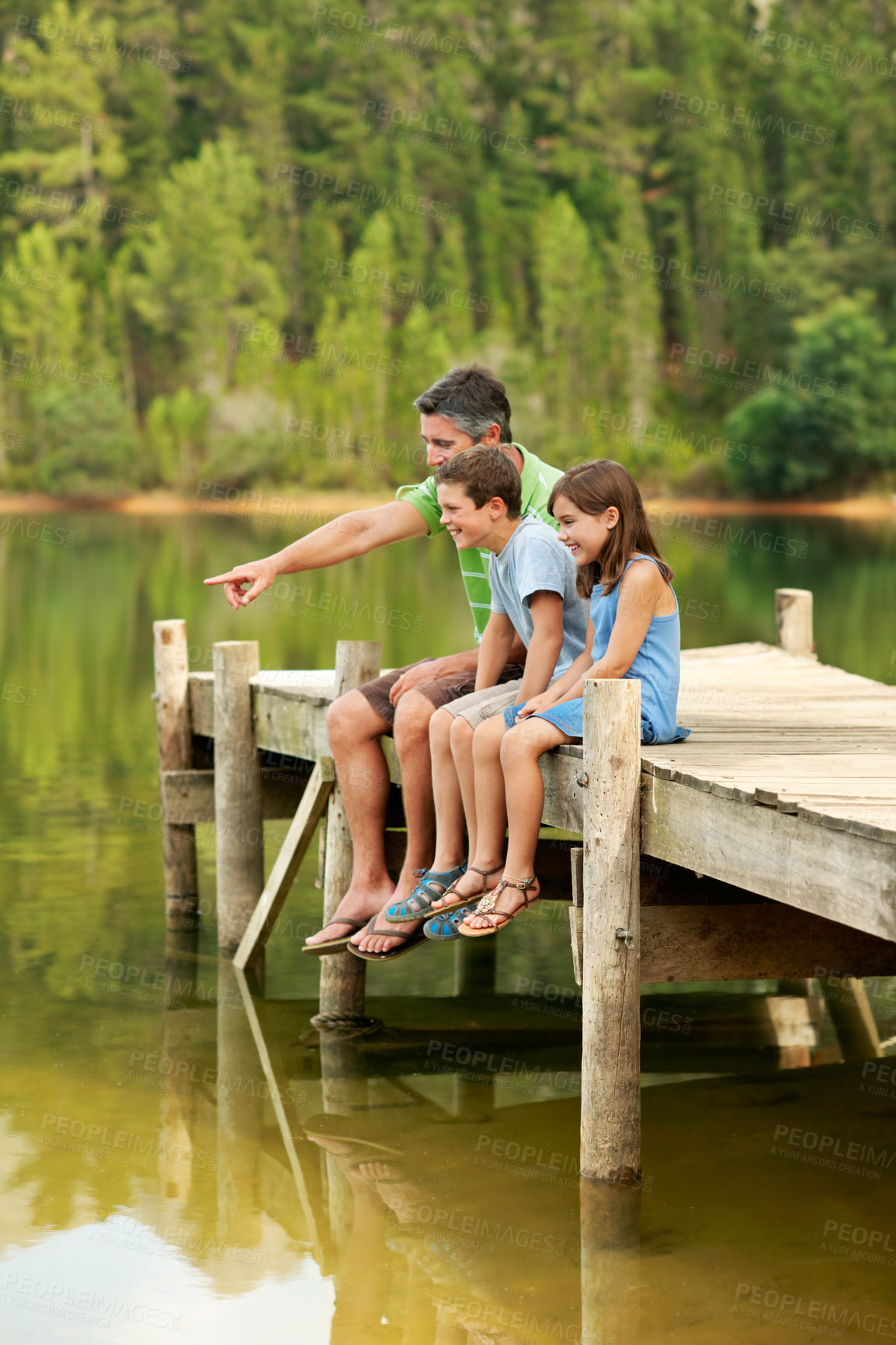 Buy stock photo Happy, father and pointing with children at lake, adventure and scenic view on holiday trip. Smile, man or hand gesture in nature with kids, wildlife observation and lakeside for sightseeing vacation