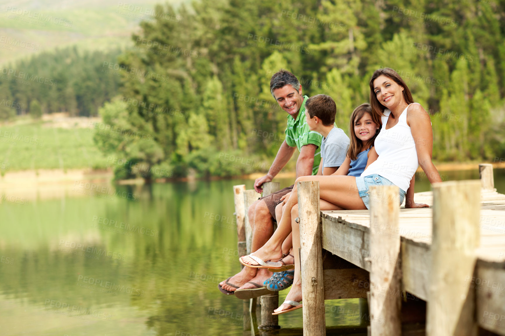 Buy stock photo Happy, parents and relax with children at lake, support and bonding together on holiday. Portrait, people and kids on dock with water, family connection and weekend break on vacation in countryside