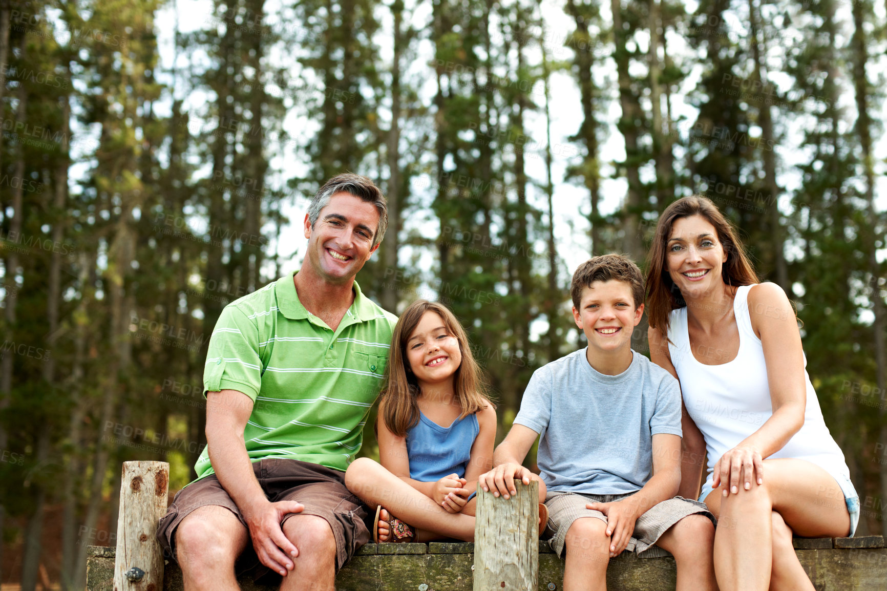 Buy stock photo Family, portrait and relax on pier for vacation with countryside, bonding and smile in nature together. Mother, father and children with dock outdoor for holiday, summer trip and travel with forest